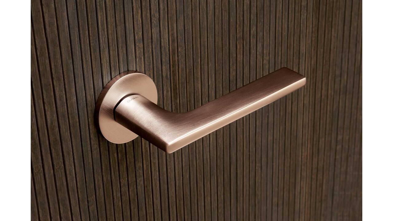 Olivari deurkruk Link + ronde geveerde rozet 51x5mm met nokken en doorgaande bevestiging Koper mat titaan PVD